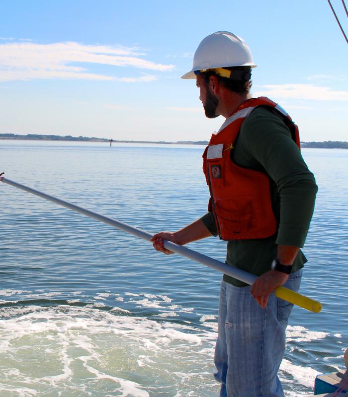 person standing in the water with a pole